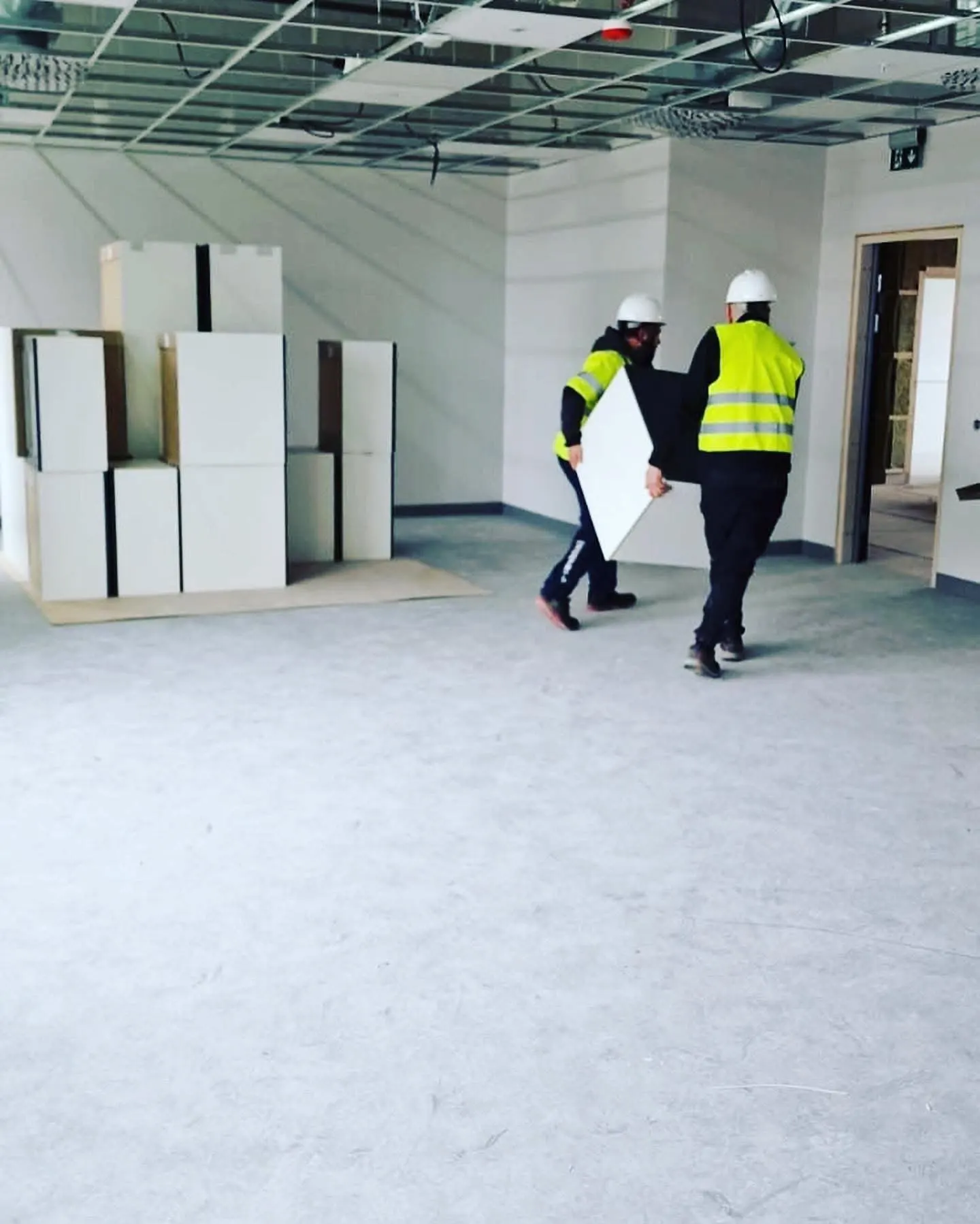 Kontorsflytt med medarbetare i bygghjälmar