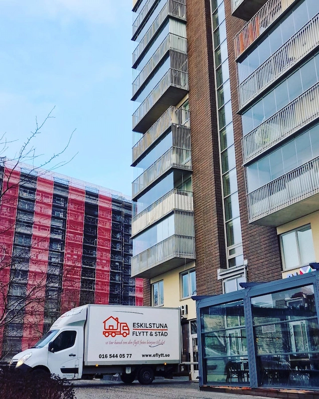 Flyttbil framför lägenhetshus
